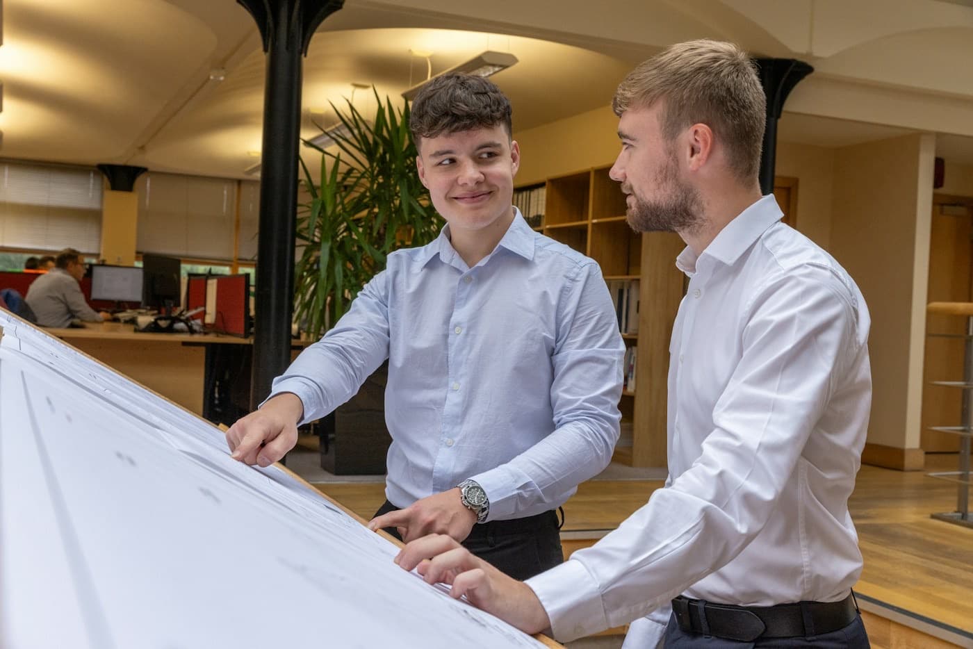 Zwei Ingenieure besprechen eine technische Zeichnung am Zeichentisch